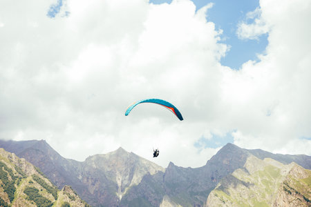 Paragliding against the backdrop of a clear blue sky and mountains.Papraplans in Chegem, Kabardino-Balkariaの写真素材