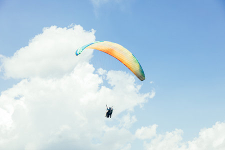 Paragliding against the backdrop of a clear blue sky and mountains.Papraplans in Chegem,...
