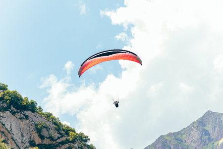 Paragliding against the backdrop of a clear blue sky and mountains.Papraplans in Chegem, Kabardino-Balkariaの写真素材