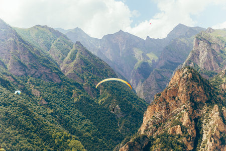Paragliding against the backdrop of a clear blue sky and mountains.Papraplans in Chegem,...