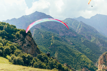 Paragliding against the backdrop of a clear blue sky and mountains.Papraplans in Chegem, Kabardino-Balkariaの写真素材