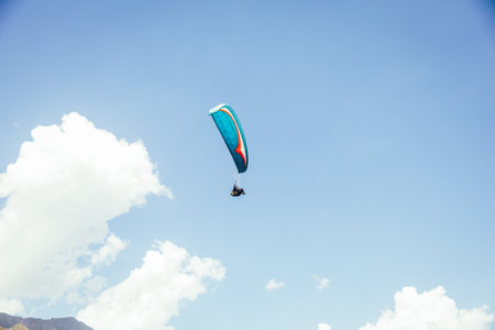 Paragliding against the backdrop of a clear blue sky and mountains.Papraplans in Chegem,...