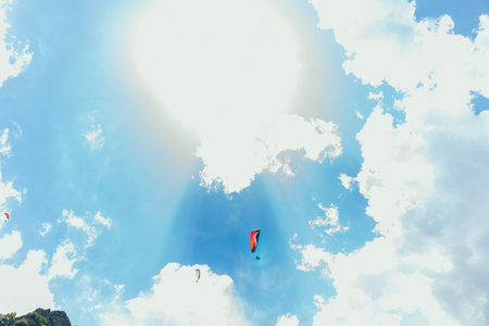 Paragliding against the backdrop of a clear blue sky and mountains.Papraplans in Chegem,...