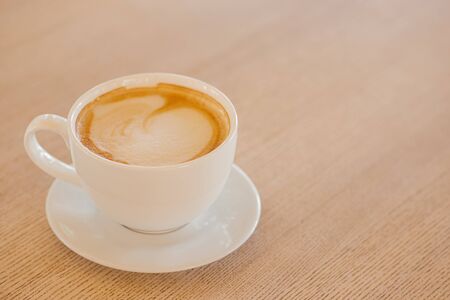 Cup of coffee on a wooden table. White ceramic cup.   Place for text.の写真素材