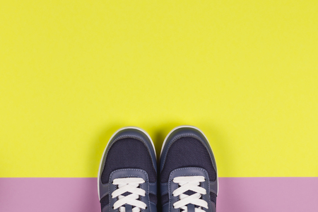 Grey sneakers on the violet and yellow background. Concept for healthy lifestyle and everyday training.  Place for text.のeditorial素材