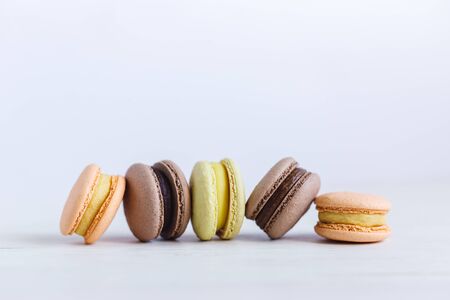 Tasty French macarons on a white wooden table. Multicolored macarons. White background. Minimal concept, place for text.の写真素材