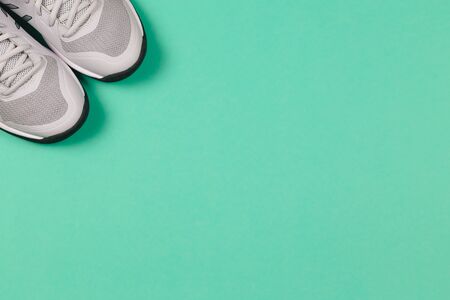 Grey sneakers on the turquoise background. Concept for healthy lifestyle and everyday training.  Place for text.の写真素材