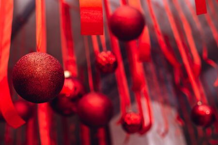 Beautiful Christmas and New Year decoration - red shiny ribbons and balls. Selective focus.