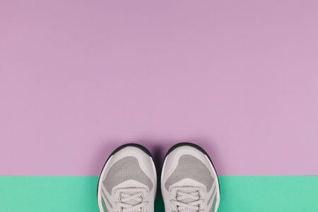 Grey sneakers on the violet and turquoise background. Concept for healthy lifestyle and everyday training.  Place for text.の写真素材