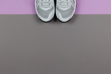 Grey sneakers on the violet and grey background. Concept for healthy lifestyle and everyday training. Place for text.の写真素材