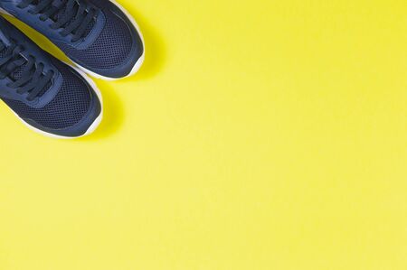 Classic blue sneakers on the yellow background. Concept for healthy lifestyle and everyday training.  Place for text. の写真素材