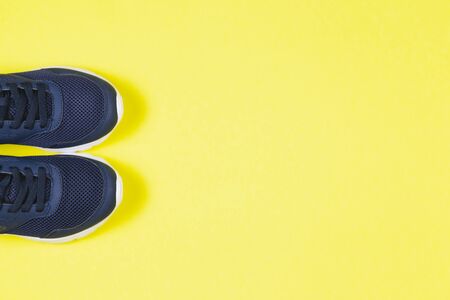 Classic blue sneakers on the yellow background. Concept for healthy lifestyle and everyday training.  Place for text. の写真素材