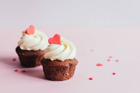 Valentine cupcakes, decorated with sweet hearts on pink pastel background. Place for text.の写真素材
