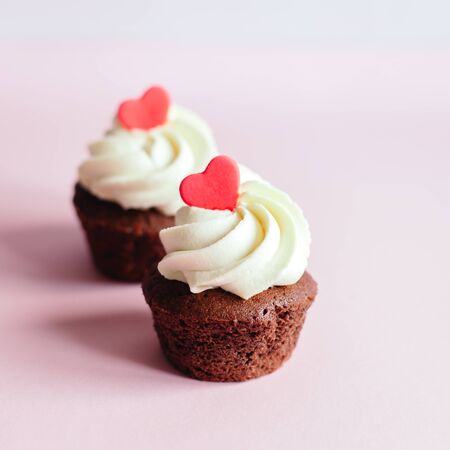 Valentine cupcakes, decorated with sweet hearts on pink pastel background. Place for text.の写真素材