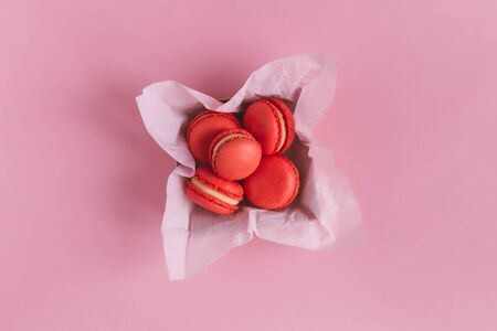 Red french macarons in a box on a pink background. Concept for Valentine's day. Place for text. Flat lay.の写真素材