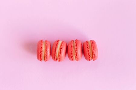 Tasty french macarons on a pink background.  Flat lay.  Place for text.の写真素材