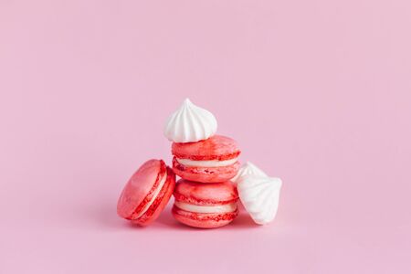 Pink macarons and white marshmallows on a pink pastel background. Place for text.の写真素材