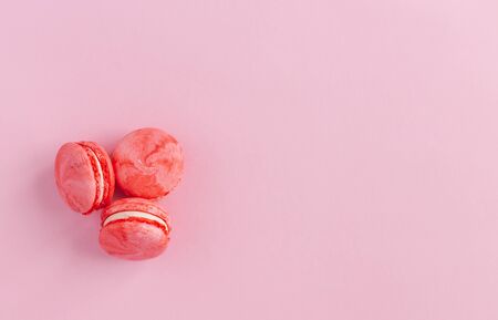 Tasty french macarons on a pink background.  Flat lay.  Place for text.の写真素材