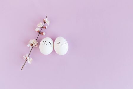 Happy easter eggs with spring blossom on a pastel violet background.  Selective focus. Place for...