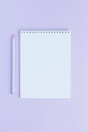 Notebook with blank page and pencil on a violet background. Flat lay. Place for text. の写真素材
