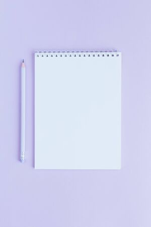 Notebook with blank page and pencil on a violet background. Flat lay. Place for text.