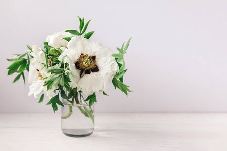 Romantic bouquet of a white peonies in a vase on a white background. Place for text.の写真素材