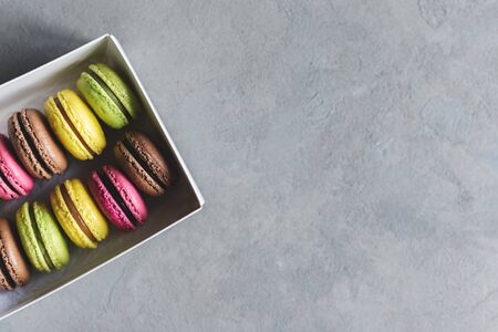 Set of tasty multi-colored french macaroons on a grey background. Pink, green and brown macaroons. Place for text.の写真素材