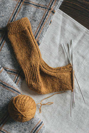 Hand knitted sock with needles and yarn ball. Concept for handmade and hugge slow life. Flat lay.の写真素材