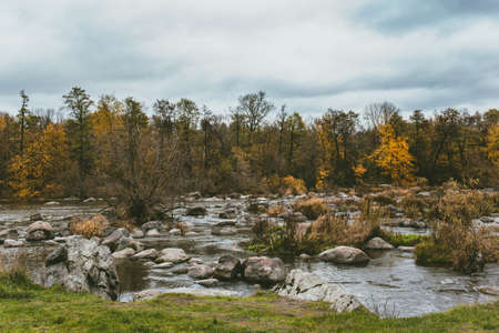 Beautiful autumn landscape with a river and a forest. Late fall. Amazing cloudy sky.の写真素材