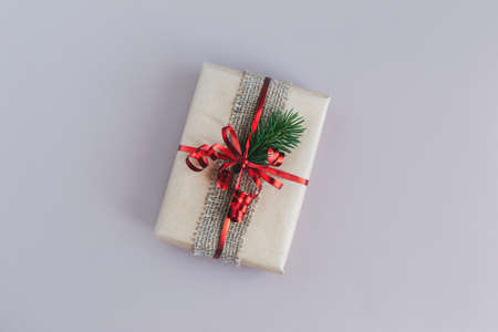 Craft gift box with spruce branch on a gray background. Holiday eco-friendly concept. Place for text. Flat lay.の写真素材