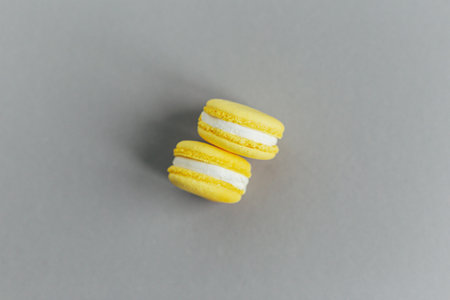 Tasty French yellow macaroons on gray