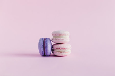 Tasty french macarons on a pink pastel background. Pink and violet macarons. Place for text.の写真素材