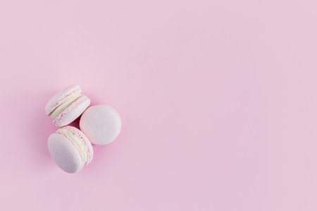 Tasty french macarons on a pink pastel background. Flat lay. Place for text.の写真素材