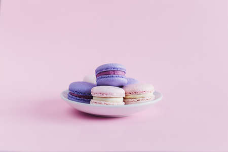 Tasty french macarons on a pink pastel background. Pink and violet macarons. Place for text.の写真素材
