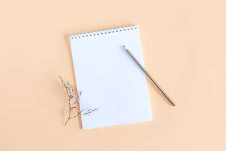 Notebook with blank page and pencil on a yellow background. Flat lay. Place for text.
