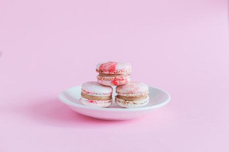 Tasty french macaroons on a pink pastel background. Place for text.の写真素材