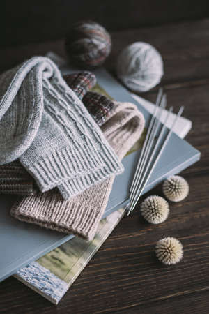 Hand knitting socks with needles and yarn balls ion a dark wooden background. Concept for handmade and hygge slow life.の写真素材