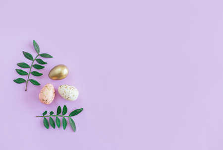 Easter background with eggs and green leaves. Pastel colors. Flat lay.の写真素材