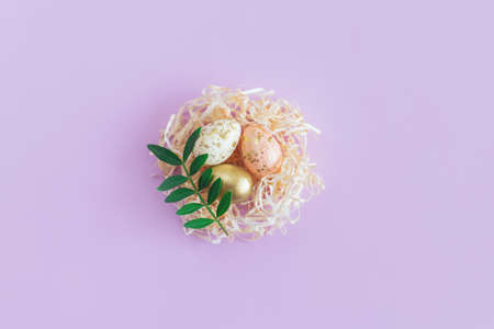 Easter background with eggs in a nest and green leaf. Pastel colors. Flat lay.の写真素材