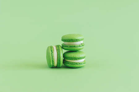 Tasty french macarons on a green pastel background. Place for text.の写真素材