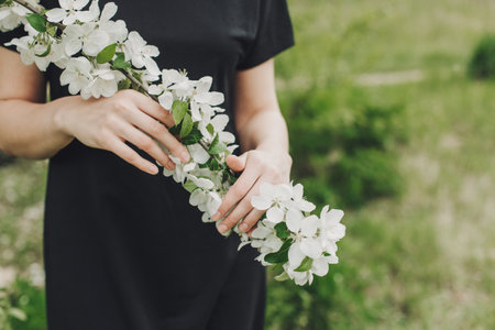 Branch of a blossoming apple tree in a woman's hands. Spring blossom. Selective focus.の写真素材