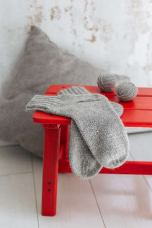 Hand knitted socks with yarn balls on a red stool. Concept for handmade and hygge slow life.の写真素材