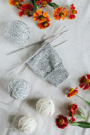 Hand knitting sock with needles and yarn balls on a dark wooden background. Concept for handmade and...