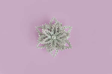 Silver snowflake on a violet pastel background. Christmas background. Flat lay. Place for text.の写真素材