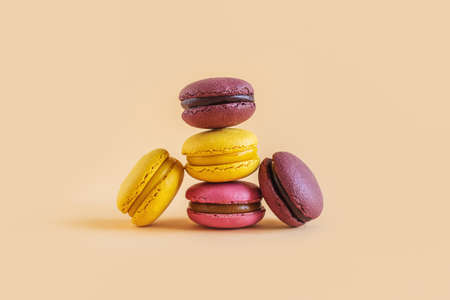 Tasty french macarons on a yellow pastel background. Place for text.の写真素材