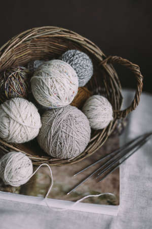 Balls of wool yarn with needles on a rustic background. Concept for handmade and hygge slow life.
