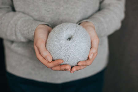 Female hands with yarn ball for knitting. minimal concept. selective focus.の写真素材