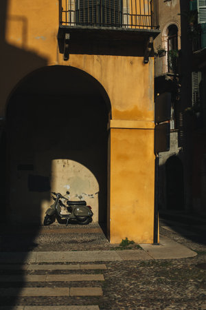 Motorcycle on a street of the old city Verona, Italy. Beautiful morning sunshine.の写真素材