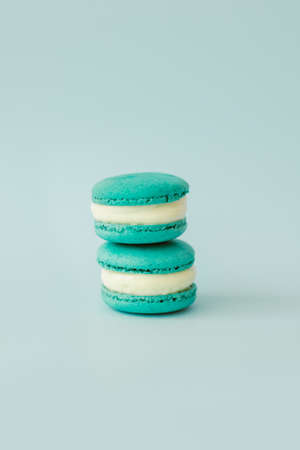 Two French macarons on a light blue background. Mint macarons. Minimal concept, place for text.の写真素材