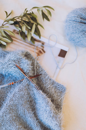 Hand knitting with needles and gray blue yarn ball on white background. Concept for handmade and hygge slow life.の写真素材